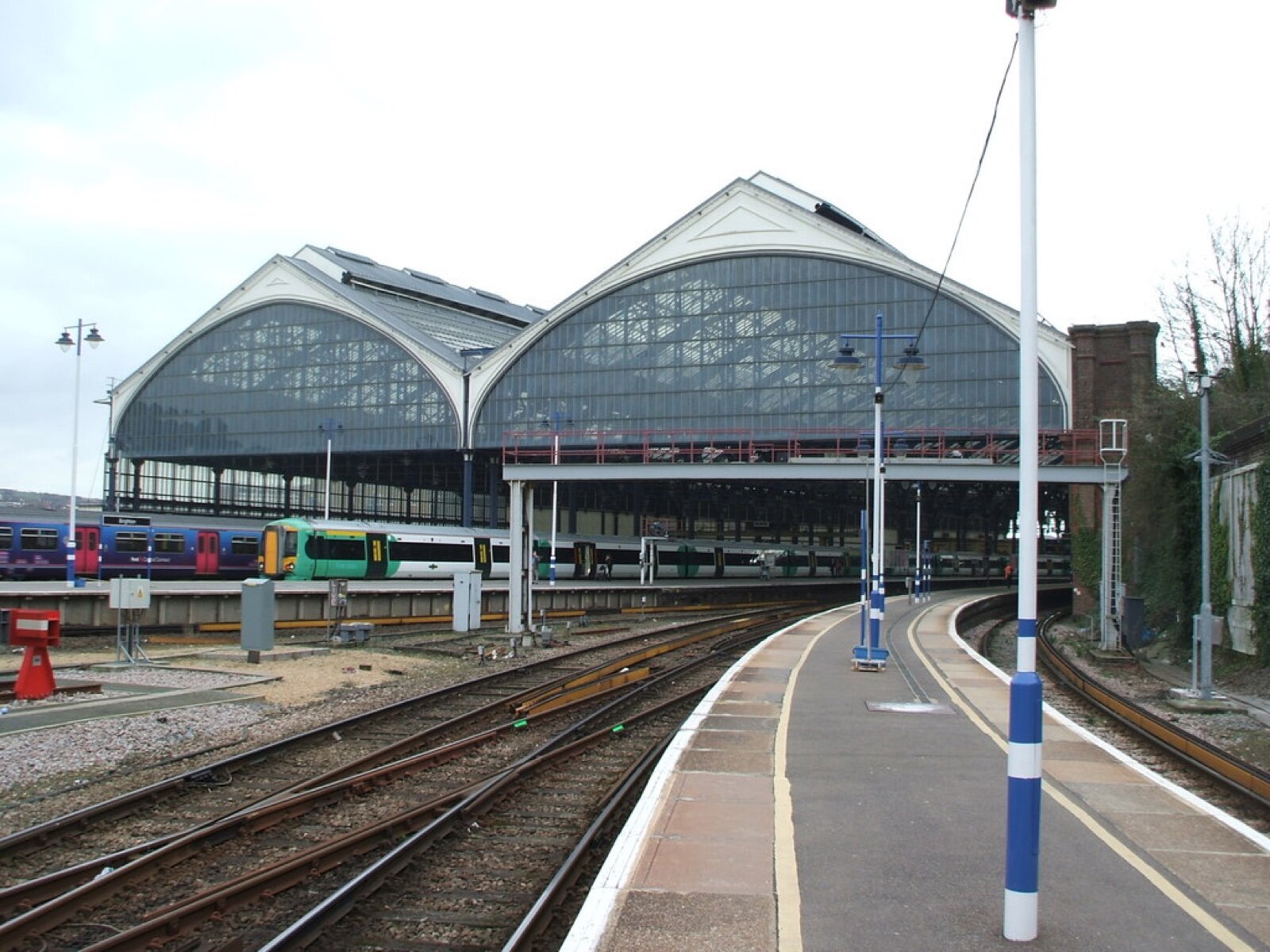 The twin arched trainsheds of Brighton railway station with a Southern train at the platform