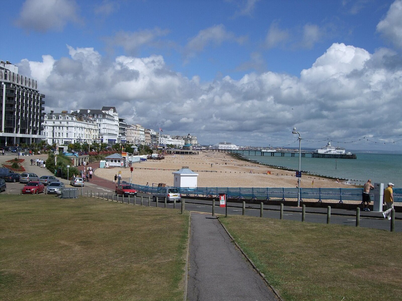 Eastbourne seafront on a sunny day, with lawns, the promenade, the beach, white seafront hotels and the pier