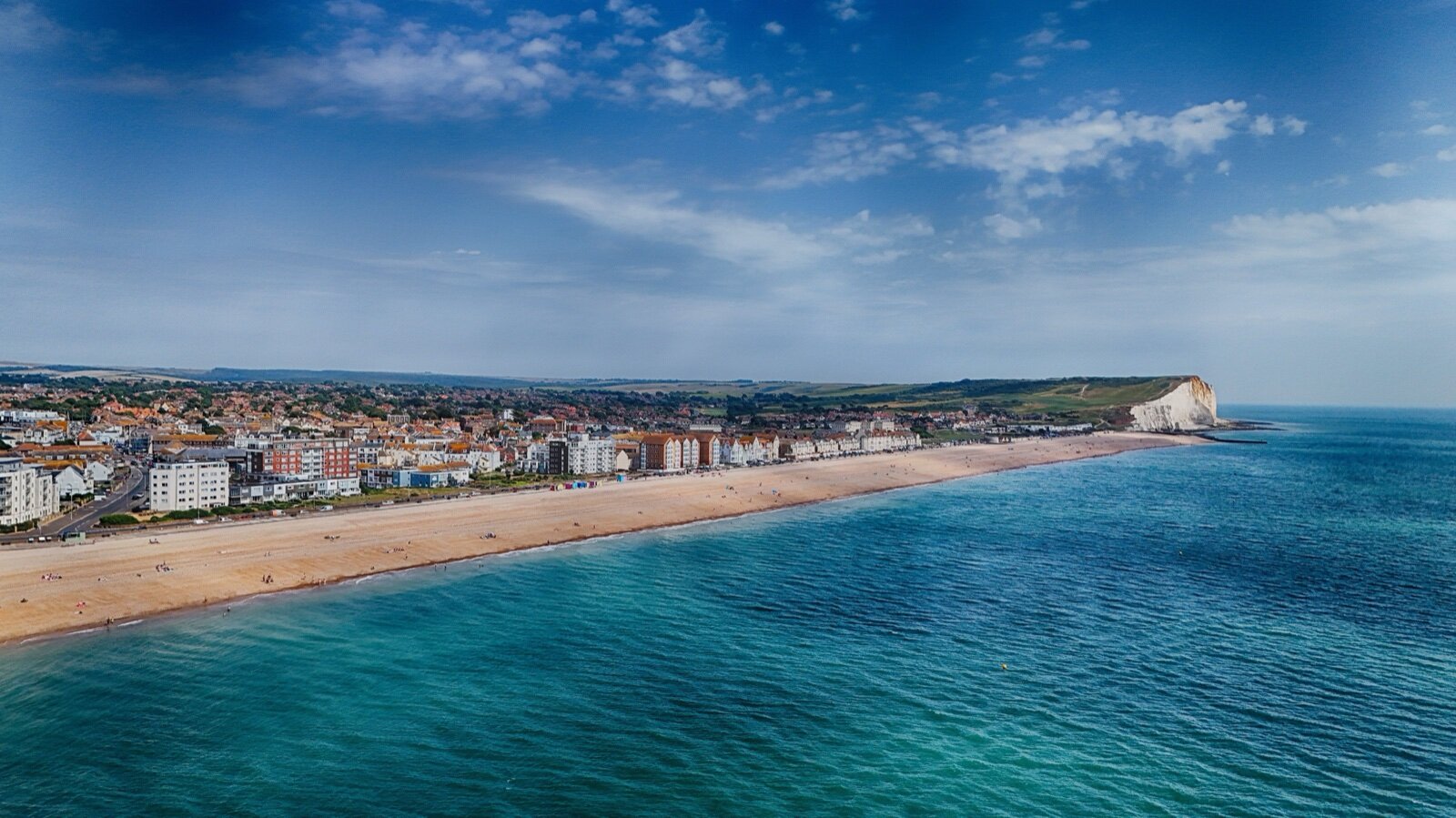 Aerial view of Seaford town and its shingle beach with the chalk cliff of Seaford Head at the far end