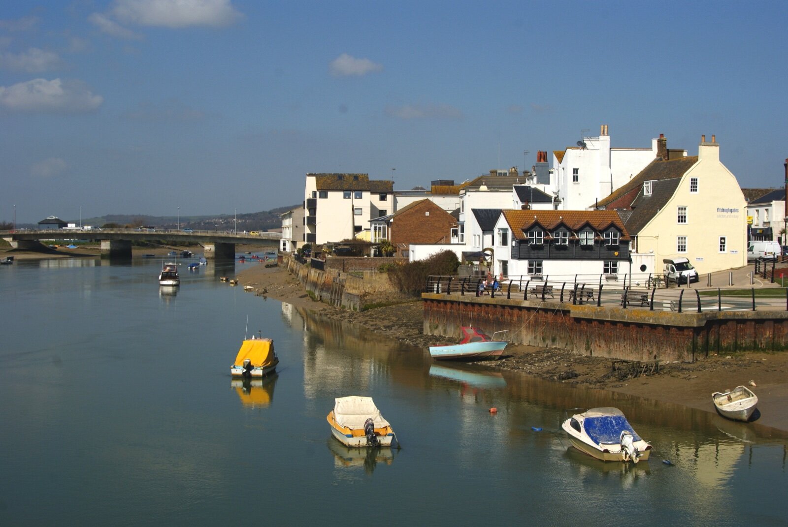 Small boats on the River Adur at Shoreham-by-Sea with riverside houses and the A259 road bridge behind