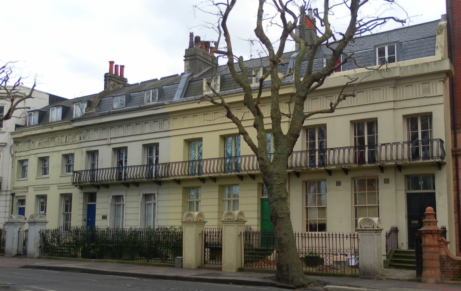 A Regency terrace of cream-fronted houses with iron balconies on Richmond Terrace in Brighton