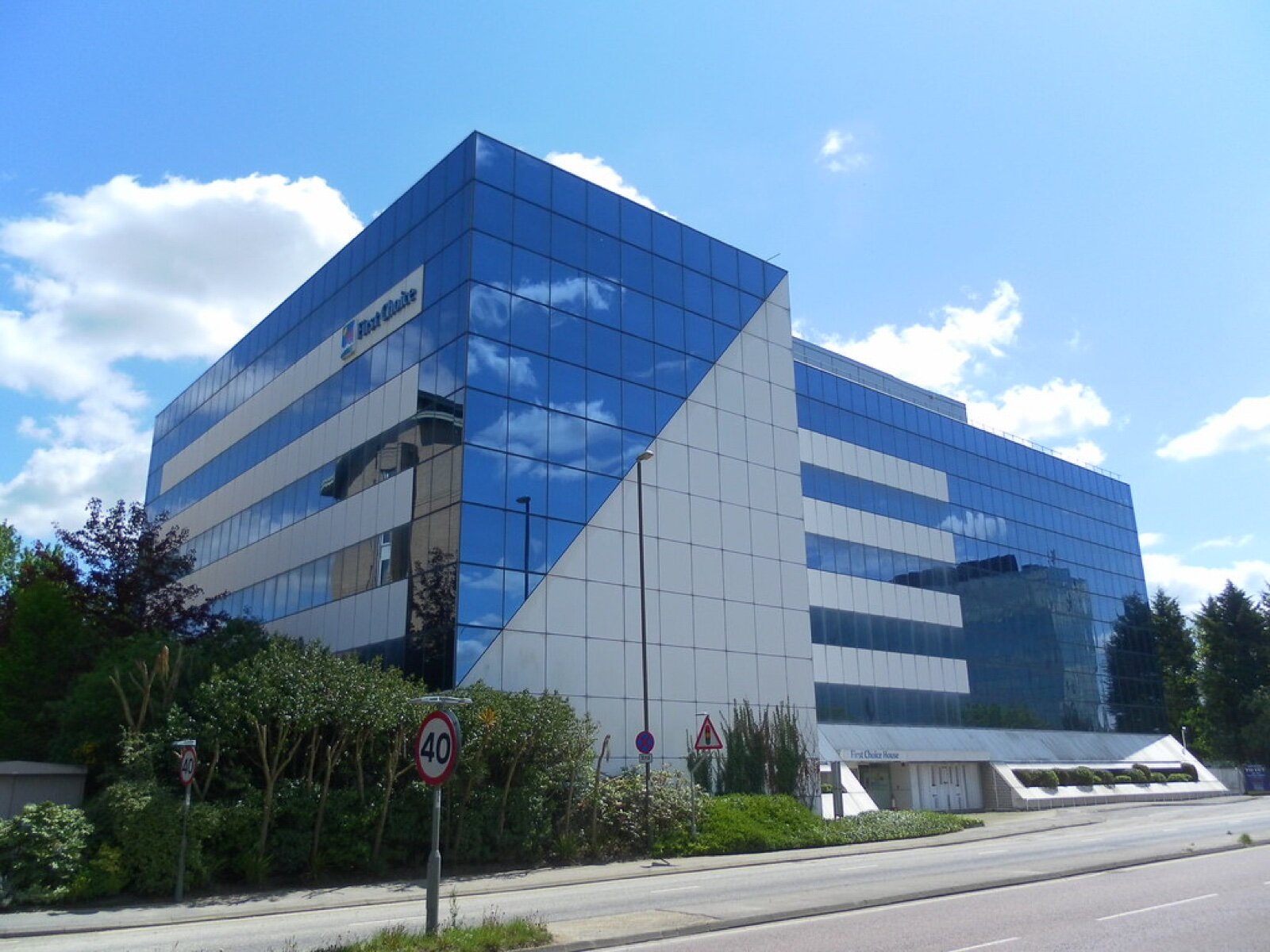 A glass-fronted office block on London Road in the Manor Royal business district, Crawley, under a blue sky