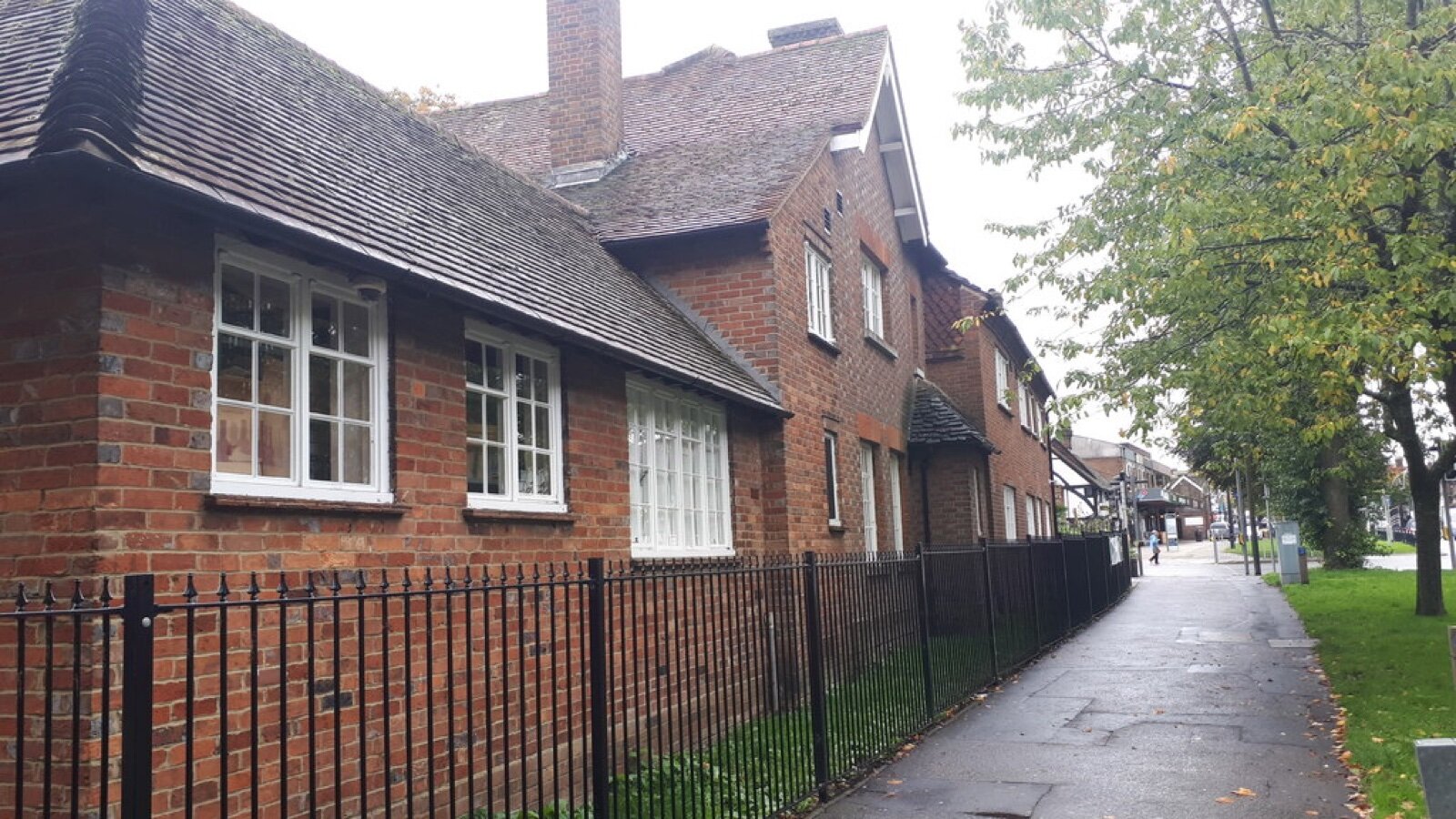 Historic buildings on the High Street in Crawley, West Sussex, with railings and a pavement running past